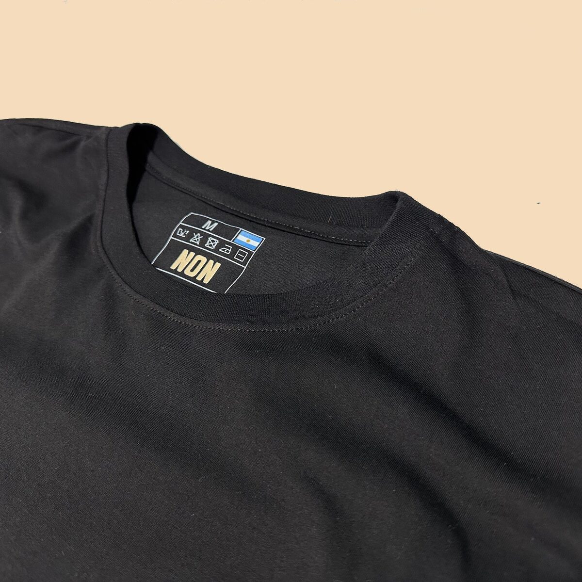Detalle del cuello y etiqueta NON en la remera Negro Intenso